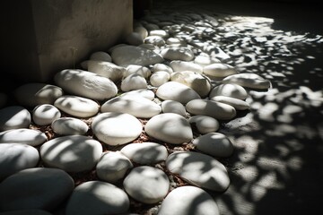 Fototapeta premium White stones on the ground. The light makes a garden with shapes and shadows.