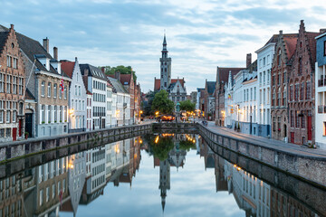 Fototapeta premium beautiful old houses and a church in bruges mirrored in canal