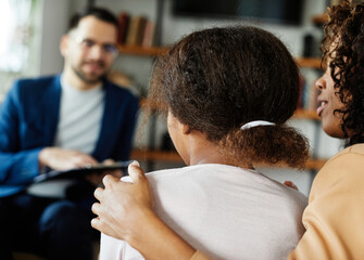 Mother with her teenage daughter at meeting with social worker, psychologist discussing mental...