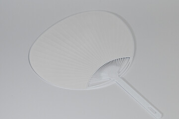 Minimalist White Plastic Uchiwa Fan on Plain Background