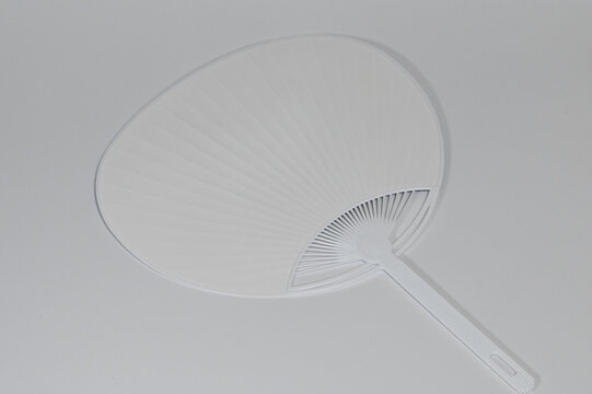 Minimalist White Plastic Uchiwa Fan on Plain Background