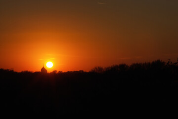Majestic golden sunset with an ancient temple silhouette perfectly framed against the glowing sun....