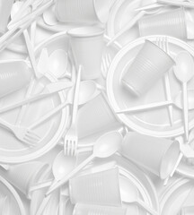 close up of plastic cutlery spoon, fork, knife, plate and cup on white background