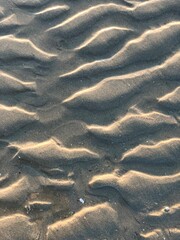 gray beach wavy sand ripples dune texture wallpaper pattern background close-up