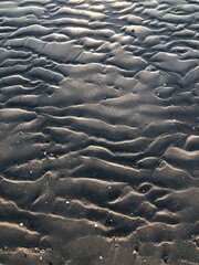 gray beach wavy sand ripples dune texture wallpaper pattern background close-up