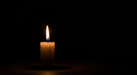 Illuminating candle flame offers a moment of calm reflection against dark backdrop evoking hope and remembrance