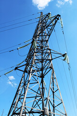 Overhead power line support against blue sky. Power transmission line.