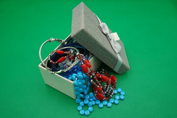 Colorful jewelry box displays a vibrant assortment of necklaces and bracelets nestled among glistening beads