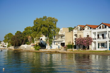 Coastal paradise captures vibrant flora and charming architecture along the serene waters at midday near a quaint harbor
