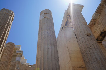 Ancient columns rise majestically against a clear blue sky, revealing the beauty of historic architecture in bright sunlight at midday