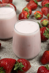Strawberry sweet yogurt in glasses among fresh, ripe strawberries.