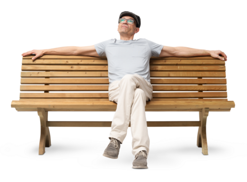 Cheerful mature man in his 50s sitting on a bench with arms resting casually, looking up and smiling. Studio image on white background, dressed in casual clothing with a hat and reading glasses