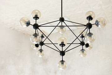 Geometry black lamp with bulbs. Modern loft chandelier on the ceiling. Molecule form lamp. Lights...