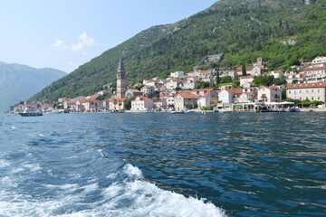 Perast coastline view from the water, showcasing the iconic bell tower, historic buildings, and...