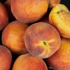 A pile of ripe fresh whole peaches close-up