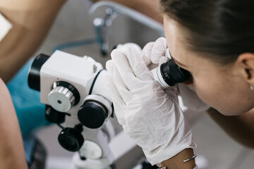 Gynecologist examines cervix using a colposcope for detailed inspection. Concept precise...