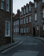 Cobblestone Street with Historic Brick Buildings. A curved cobblestone street lined with charming...