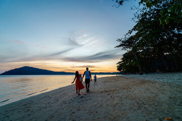 Family walks on the beach on Koh Chang island. Family-Friendly beaches in Thailand ensure everyone...