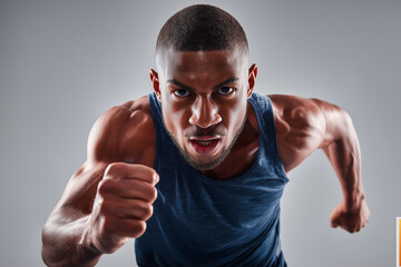  young athlete mid-stride with fists clenched and brows furrowed, intense focus in the eyes