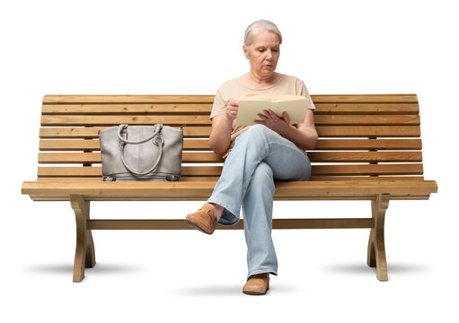 Mature woman in her 50s sitting on a wooden bench, reading a book. Studio shot isolated on white background. She is casually dressed