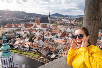 Mujer turista sorprendida por las hermosas vistas de la ciudad de český krumlov que pueden verse desde el mirador del castillo