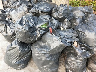 Pile of Black Garbage Bags on Sidewalk