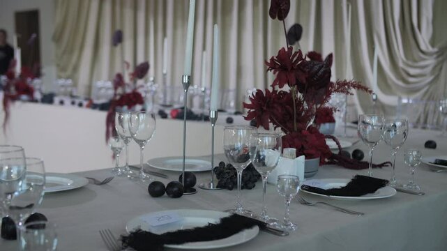 Elegant banquet table with red flowers and black accents