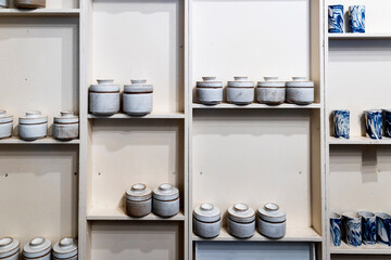 Ceramic Jars and Mugs Are Displayed on Shelves.