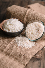 Fresh White Rice Falling into Wooden Bowl, Rice in a wooden bowl on wooden table., White rice close-up shot, White rice grains falling from a glass jar into a red bowl, White Rice Grains Pouring 