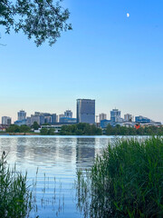 City near lake at sunset. Downtown Minsk and Lake Drozdy. Long Panoramic River Downtown City Skyline. Panarama of City with buildings and  houses on waterfront. buildings and downtown city skyline