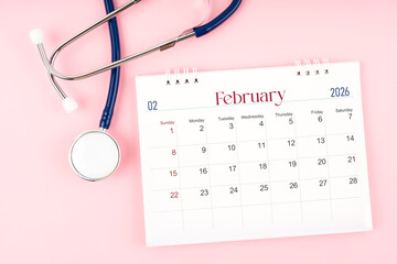 Blank February 2026 desk calendar and stethoscope, Medical appointment schedule to check up.