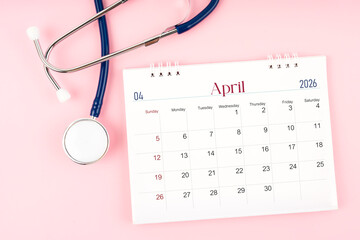 Blank April 2026 desk calendar and stethoscope, Medical appointment schedule to check up.