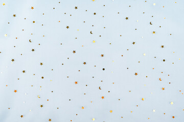 Holiday background with little golden stars on blue color background.