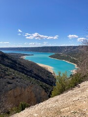 An aerial view of Gorge Du Verdon river winding through the bottom of the valley with forest and cliffs either sides.