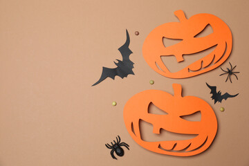 Halloween with orange pumpkins, black bats, autumn leaves on beige background