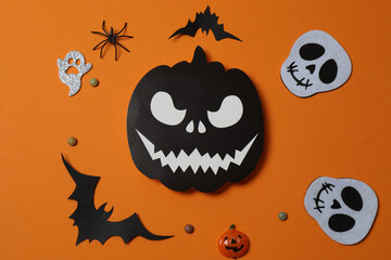 Halloween with orange pumpkins, black bats, autumn leaves on orange background