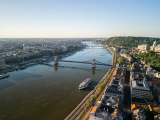 Drone photo over the Danube in Budapest showing Chain Bridge and the cruise boat Europa at sunrise,...