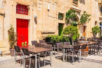 A cafe with outdoor sitting area in Valletta waterfront in Floriana, outside of Valletta, Malta.