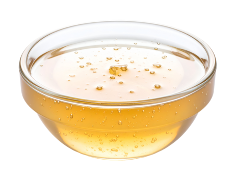 Golden liquid honey with delicate bubbles glistens in a clear glass bowl, showcasing its sweet, natural essence.