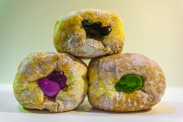 Indonesian sweet cakes served on natural wooden plate and spoon with black background highlighting...