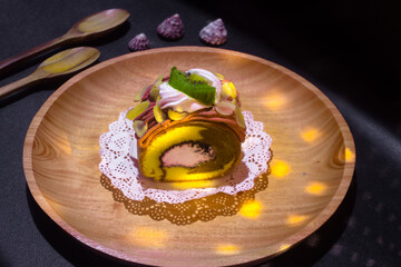 Indonesian sweet cakes served on natural wooden plate and spoon with black background highlighting traditional dessert texture and authentic tropical food style