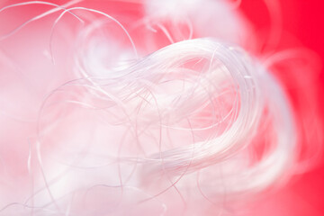 Extreme macro of polyester stable fiber on red background. Selective focus, shallow depth of field....