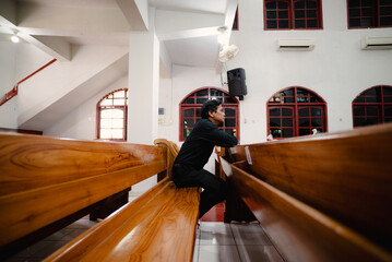 Contemplative man sits alone in a church, reflecting on faith and introspection