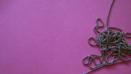 Furniture, beads for diy A vibrant purple backdrop featuring a twisted silver chain, ideal for holiday crafts.
