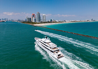 Luxury yacht cruising near Miami skyline. Aerial view of boats on turquoise waters in Miami. Yacht retreat in South Florida Miami.