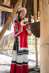 Obraz premium Vertical pretty Mongolian girl in traditional Mongolia attire in yurt or Mongol tent