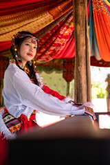 Young pretty Mongolian girl in colorful traditional Mongol costume in tepee house