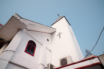 Architectural perspective of a bright white church building with a cross symbol on the facade.
