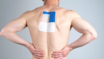 Bare-chested man with back support tape, hands on hips