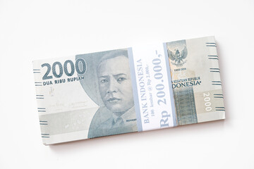 A stack of Indonesian rupiah Rp 2.000 banknotes isolated on white background for THR on Eid al-Fitr or Lebaran days